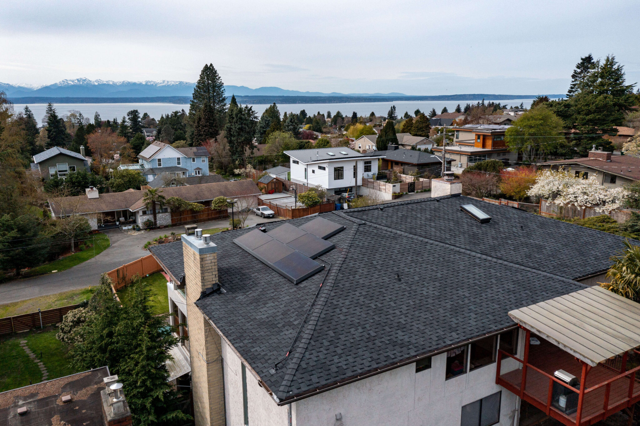 Tesla solar panel system in North Seattle with Olympic mountain range in the background