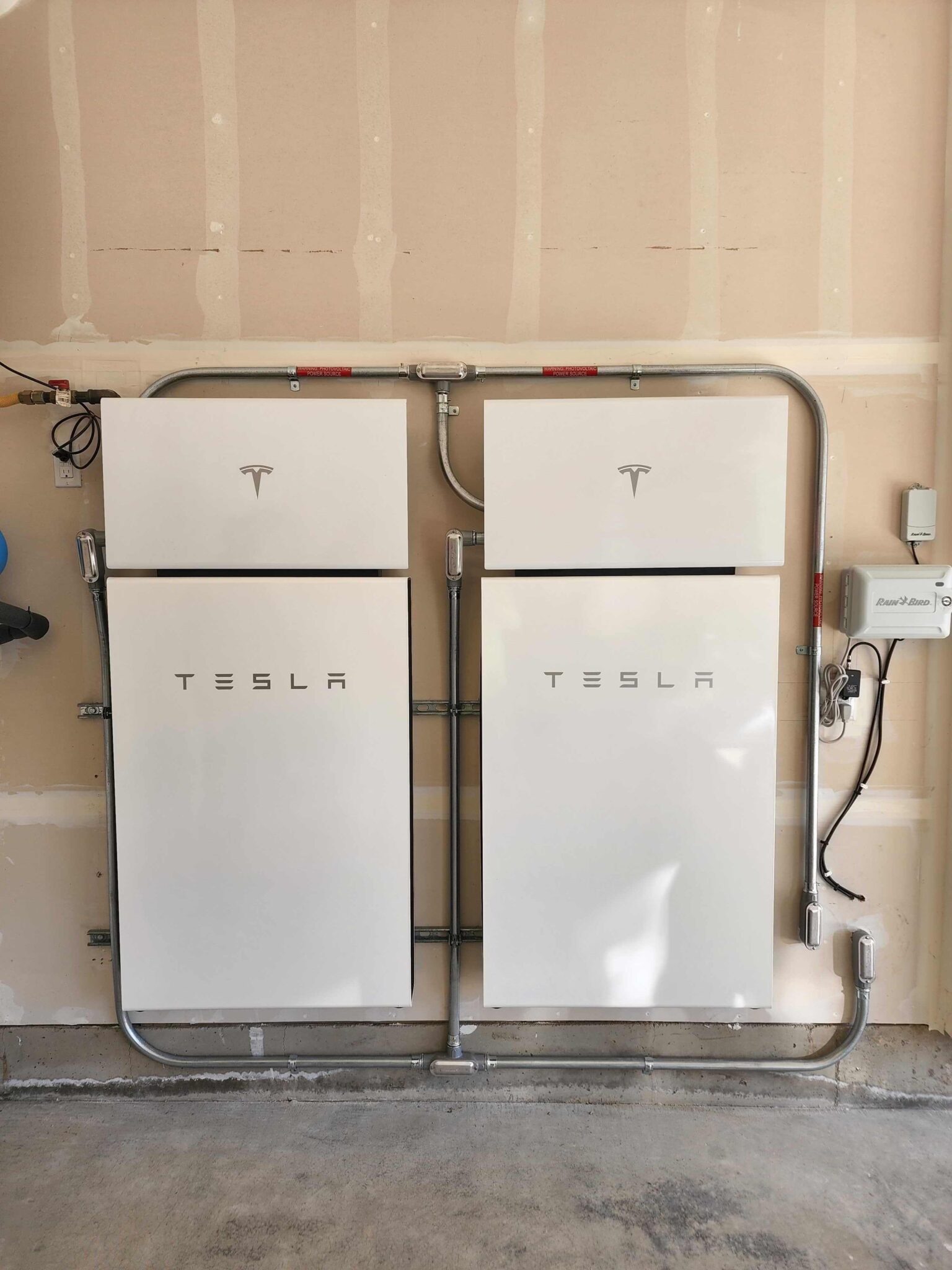 two powerwall plus battery systems installed inside a garage