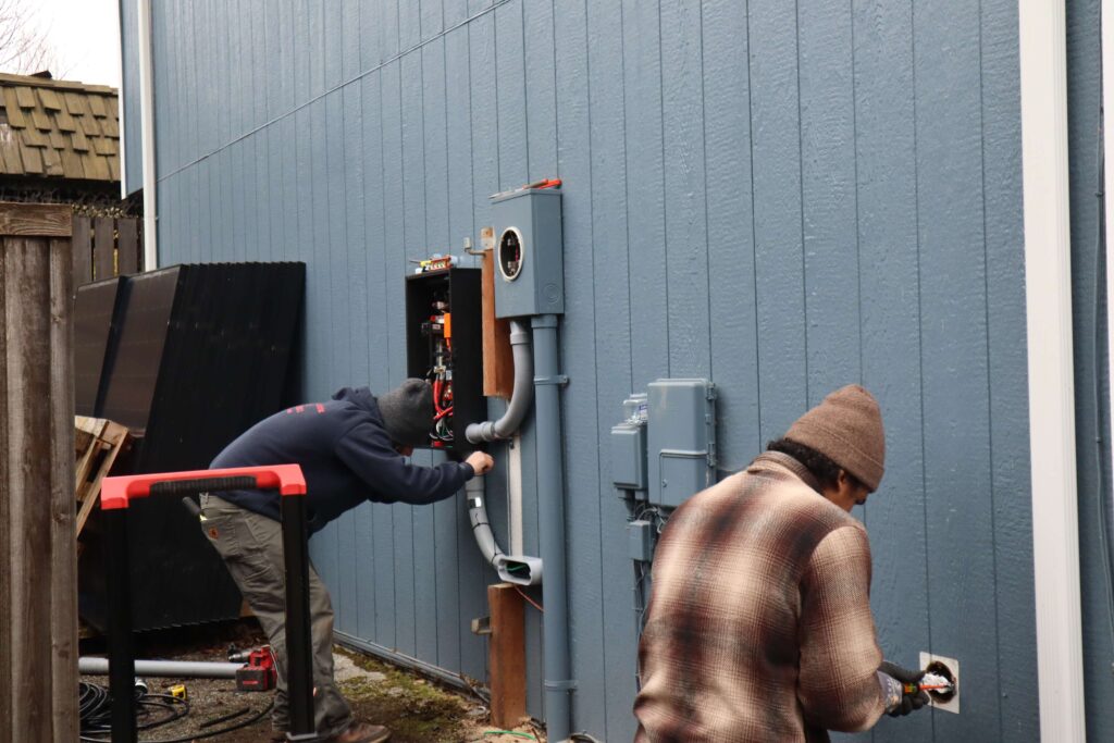 NWES workers installing equipment next to the meter