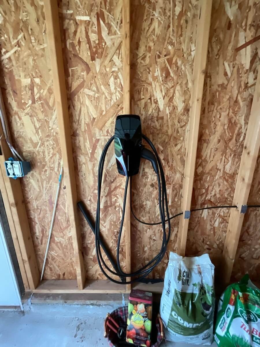 Black Tesla Wall Connector Installed on beam inside garage